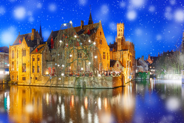 Medieval fairytale Old Town and tower Belfort from the quay Rosary, Rozenhoedkaai, in snowy evening, Bruges, Belgium