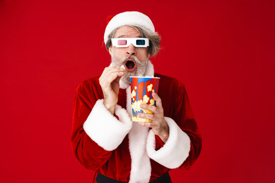 Image of old Santa Claus man in 3D glasses holding popcorn bucket