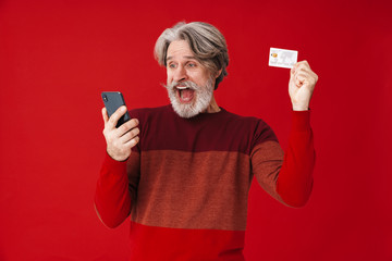 Portrait of gray-haired old man holding smartphone and credit card