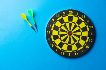 Target and darts for playing on a blue background