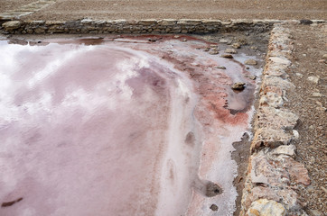 Salina con agua rosa y reflejos del cielo en Formentera