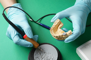 Girl models a wax tooth with an electric spatula