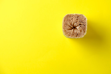 Pack of wooden toothpicks on a yellow background