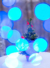 Artificial Christmas tree on a stump in the winter forest
