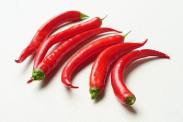 Hot peppers on a white table, side view