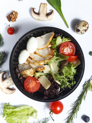 Culinary dishes made from natural products in a plastic bowl on the background with ingredients for cooking. Healthy food delivery concept. Top view.