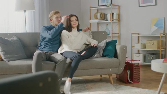 Young Couple Use Augmented Reality, Swiping and Choosing Media Content to Watch in their Living Room. Girlfriend and Boyfriend. For Motion Tracking Video Editing, Tracking Points Added on Furniture