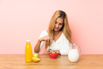 Young blonde woman having breakfast milk