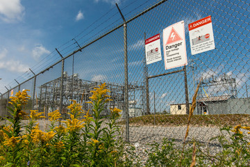 Danger High Voltage Signs on the exterior electric fence of an electrical substation, written with...