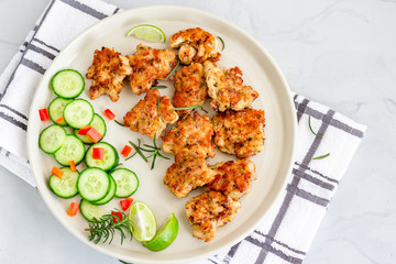 Chicken Fritters in a Plate with Cucumber Slices and Lemon, Rosemary, Top View Food.