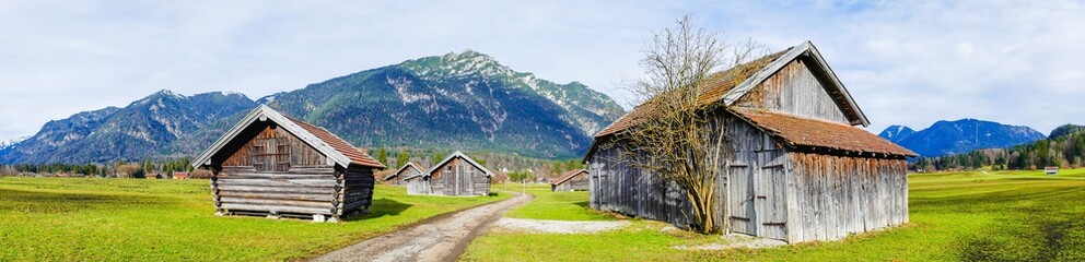 Fototapeta na wymiar Panorama Weg zwischen Scheunen Alpen