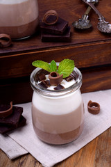 Three chocolate mousse dessert in a glass jar with mint