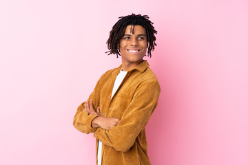 Obraz na płótnie Canvas Young African American man with corduroy jacket over isolated pink background with arms crossed and happy