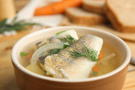 Delicious fish soup in bowl on table, closeup view