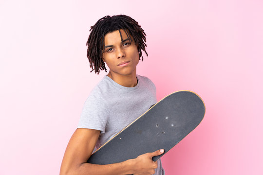 Young African American skater man over isolated pink wall