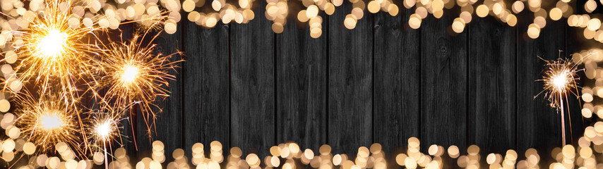 Silvester background banner panorama long- Frame made of sparklers and bokeh lights on rustic...