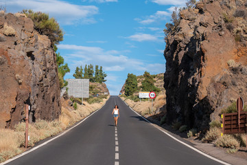 young Female walking on the road in Teide volcano crater