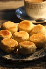 Artistic Delicious Indonesian Bakpia Yogyakarta Cookies Cake and Coffee Cappuccino Beverages for Breakfast in Wooden Rattan Table Background 