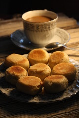 Artistic Delicious Indonesian Bakpia Yogyakarta Cookies Cake and Coffee Cappuccino Beverages for Breakfast in Wooden Rattan Table Background 
