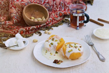 Dessert of stewed quince in syrup, poured with custard on a white plate on a light concrete background. Healthy desserts. Turkish cuisine.