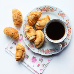 cup of coffee and fresh croissants with white background