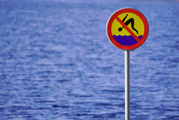 sign prohibiting diving on the background of water, river or lake. the safety of people, shallow body of water.