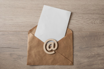 Blank paper envelopes on light wood table background.