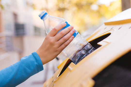 Stock Photo Of A Woman's Hand Recycling A Plastic Bottle