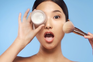 portrait of young woman applying blusher