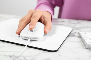 Woman using modern wired optical mouse at office table, closeup