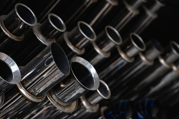New and used motorcycle exhaust chrome pipes in a motorcykles shop or in service center.