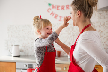 Happy mum and daughter touching each other nose