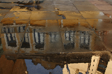 Prédios do centro histórico de São Paulo refletidos em piso molhado