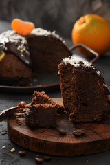 Traditional festive dessert. Steam chocolate pudding with orange and clementine cut on wood slab on...