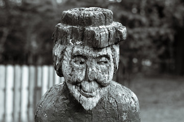 Creepy wooden old woman. Wooden figure of an old smiling witch