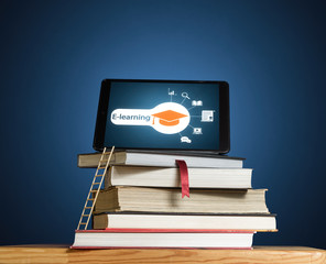 Stack of books with ladder and tablet pc on the desk. Concept of online education, e-learning,...