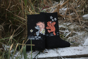 black felt boots with a pattern on the snowy grass