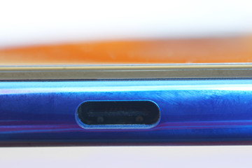 USB Type-C port on the edge of a blue smartphone. Modern technologies.
