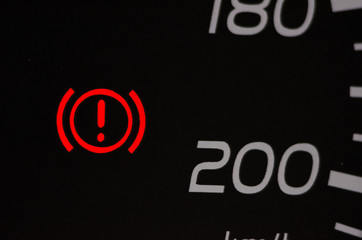 Parking brake indicator lamp in the dashboard of the vehicle is lit in red