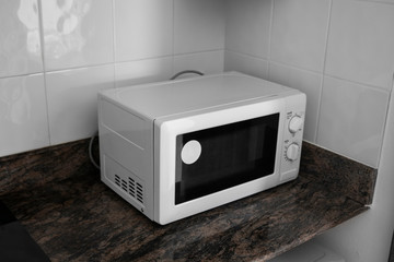 Microwave in a kitchen for cooking or heating a dish.