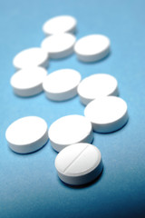 Pills / Pills in the form of dollar sign on blue background. Medical concept