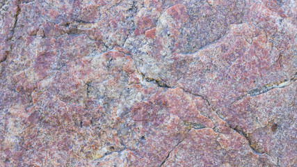 Texture of granite. Granite rock with reddish color. Background from solid stone. Pattern with natural material. Widescreen