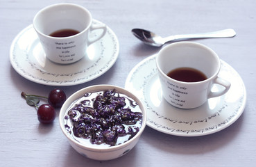 cup of coffee, cherry and cookies on white background