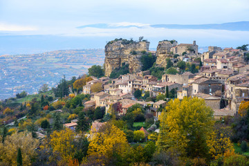 Fototapeta premium Vue panoramique sur le village de Saignon en automne, Provence, Luberon, France. Mont Ventoux enneigé en arrière-plan. 