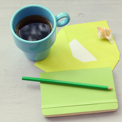 notebook and cup of coffee on wooden table
