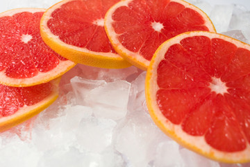 Naklejka na ściany i meble Grapefruit slices on ice. Close-up.