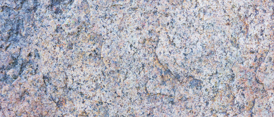 Granite texture. Granite rocks with porous surface. Background from solid stone. Pattern with natural material. Widescreen