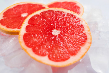 Naklejka na ściany i meble Grapefruit slices on ice. Close-up.