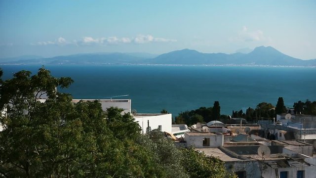 Sea and mountains at Sidi Bou Said, Tunisia. Sidi Bou Said has a reputation as a town of artists, it's a tourist attraction and is known for its extensive use of blue and white.