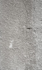 Cracked concrete grey wall covered with gray cement texture as background can be used in design. Dirty concrete texture with cracks and holes.